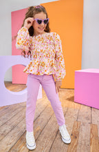 Load image into Gallery viewer, Young girl in a colorful outfit with sunglasses standing in front of colorful geometric shapes.