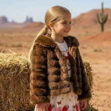 Load image into Gallery viewer, Young girl in a fur coat standing next to a hay bale in a desert setting
