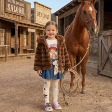 Load image into Gallery viewer, Young girl in a fur coat standing next to a horse in a western-themed setting
