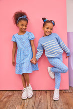 Load image into Gallery viewer, Two young girls in matching blue outfits standing against a pink wall.

