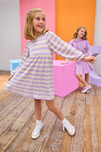 Load image into Gallery viewer, Two young girls in pastel striped dresses standing in a room with colorful walls.
