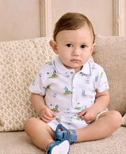Load image into Gallery viewer, Baby sitting on a couch wearing a white outfit with green and blue golf patterns.
