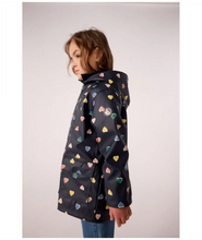 Load image into Gallery viewer, Girl wearing a navy raincoat with colorful heart patterns 
