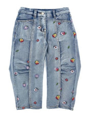 Load image into Gallery viewer, Blue jeans with colorful floral patches on a white background
