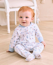 Load image into Gallery viewer, Baby sitting on a wooden floor wearing colorful puppy pajamas.
