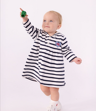 Load image into Gallery viewer, A baby wearing a navy and white horizontally striped long-sleeve dress with a small heart PB logo on the left chest
