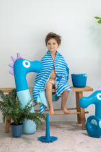 Load image into Gallery viewer, Child wrapped in a blue and white striped towel sitting on a stool with blue inflatable toys around.
